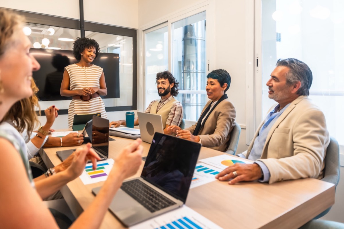 A business team collaborating around laptops in a bright office